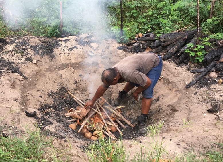 Lighting a fire in a biochar pit.